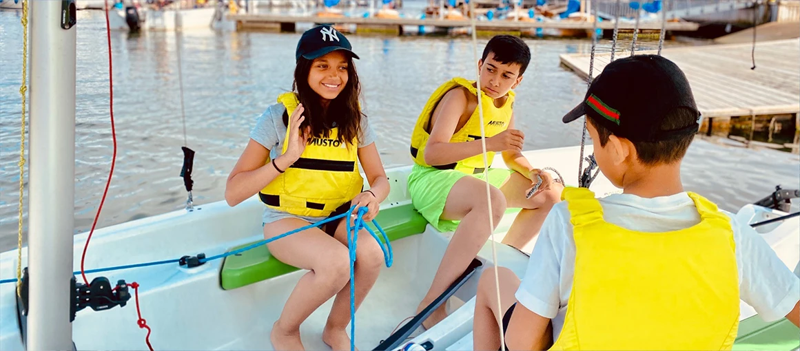 Kids sitting in a small sailingboat.